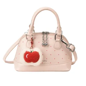Pink polka dot shell handbag with apple charm and metallic chain puller for women