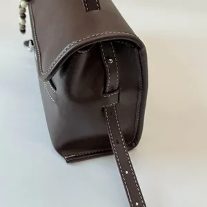 Dettaglio della borsa tote in pelle marrone scuro con cuciture bianche a contrasto