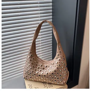 Dettaglio della borsa hobo beige con borchie metalliche argentate e pelle sintetica opaca