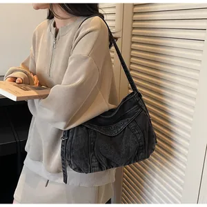Détail du sac à épaule en denim noir avec gaufrage MUBELETING et texture plissée élégante