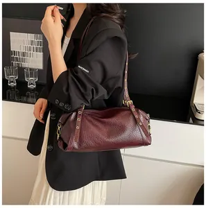 Detail of burgundy leather Boston bag with vintage gold zippers and eyelet shoulder strap