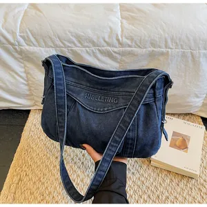 Détail du sac cabas en denim bleu avec broderie SUBELETING et design à texture plissée
