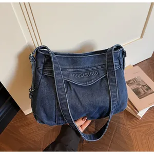 Détail du sac cabas en denim bleu foncé avec broderie SUBELETING dans un décor vintage