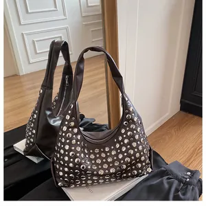 Dettaglio della borsa hobo marrone scuro con borchie metalliche argentate e cerniera