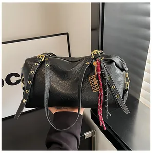 Close-up of black lychee leather Boston bag with eyelet straps and abacus charm