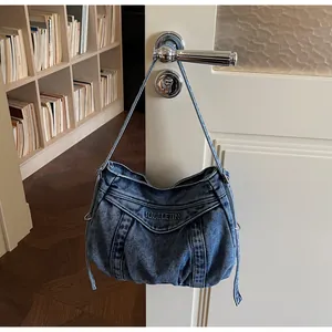 Détail du sac hobo en jean avec design froncé et boucles en métal argenté brillant