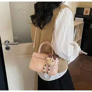 Pink PU leather handbag with cute bear charm and decorative buckle detail