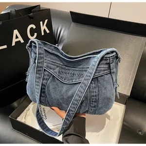 Détail du sac à épaule en jean bleu avec broderie SUBELETING et fermeture éclair