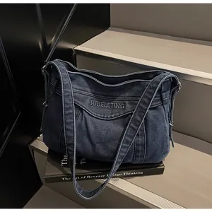 Détail du cabas en denim bleu foncé avec broderie SUBELETING et texture délavée