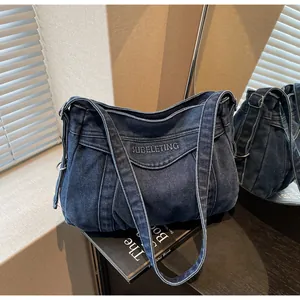 Détail du sac bandoulière en jean bleu avec logo Subeleting et texture plissée