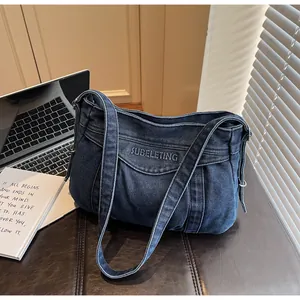 Détail du sac cabas en denim bleu avec broderie SUBELETING et finition délavée