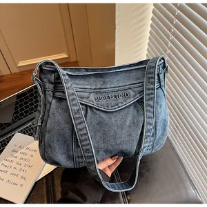 Détail du sac en jean bleu avec broderie noire SUBELETING et texture de tissu délavé