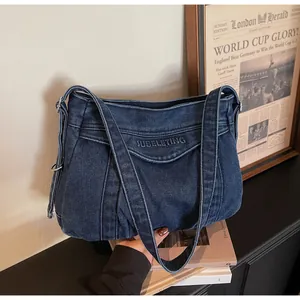 Détail du sac cabas en denim bleu foncé avec broderie SUBELETING et boucle en métal