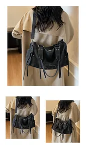 Detail der schwarzen Motorrad-Tasche mit Nieten, Kordelzügen und Schnallentasche