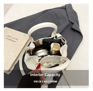Capacité interne du sac seau blanc en cuir avec téléphone, cosmétiques et charme en peluche