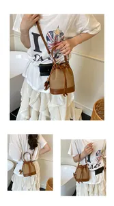 Détail du sac seau bicolore avec fermeture à cordon et breloque cheval en cuir