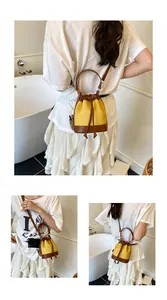 Détails du sac seau en toile jaune et cuir marron avec fermeture à cordon et bandoulière