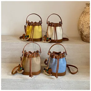 Détail de sacs seaux bicolores avec cordon de serrage et charm de cheval de bois