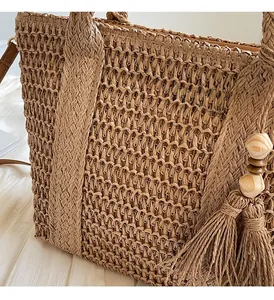 Close-up of woven straw tote bag texture with wooden bead tassel and soft lining