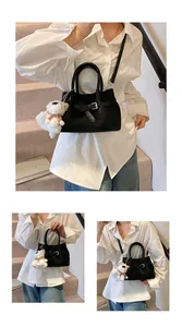 Détail du sac seau noir avec boucle de ceinture et pendentif ours en peluche blanc