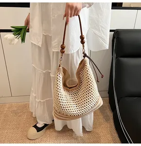 Dettaglio della borsa tote intrecciata con tracolla in perline di legno marrone