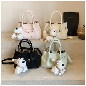 Détail de sacs seaux pastel en quatre couleurs avec charmants pendentifs chiots