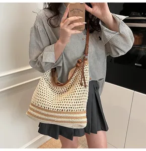 Dettaglio della borsa tote intrecciata a mano con trama in cotone beige e cinturino