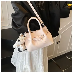 Détail du sac à main rose tressé avec charm chiot en peluche et boucle décorative