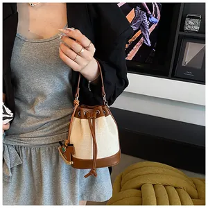 Détail d'un sac seau en toile avec bordure en cuir et pendentif cheval en bois