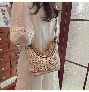 Dettaglio della borsa tote in maglia con tracolla in pelle marrone e perline di legno