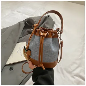 Détails du sac seau bicolore avec cordon en cuir et pendentif charmant de poney