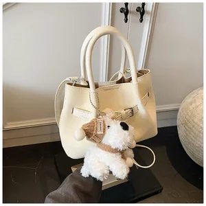 Détail du sac à main tissé avec boucle réglable et joli pendentif en peluche pour chien