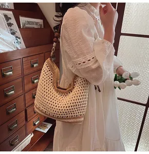 Dettaglio della borsa tote intrecciata a mano con perle in legno e fibbia in metallo