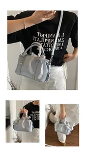 Close-up of light blue Boston bag with white lace bow and heart metal charm detail