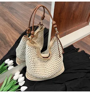Dettaglio della borsa tote intrecciata a mano con perline di legno e manici in pelle