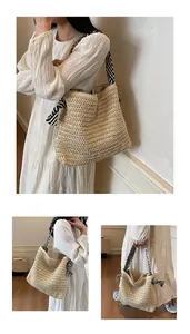 Detalle de bolsa de paja con correas de rayas blancas y negras y adorno de nudo