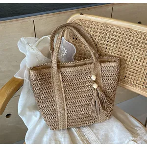 Detailed straw woven tote texture with wood bead tassel and fabric lining for beach vacation