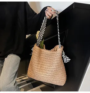 Detalle del bolso tote de paja tejida con asas de rayas blancas y negras y textura fina