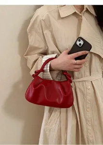 Rote gefaltete Lederhandtasche mit Knotengriff am Arm eines Models präsentiert