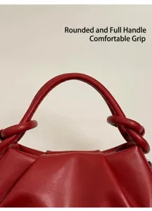 Detail der roten Leder-Cloud-Bag mit abgerundeten Griffen und weicher Faltenstruktur