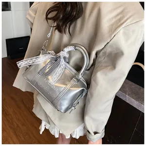 Detail view of silver Boston bag with lace bow and logo embossing for women
