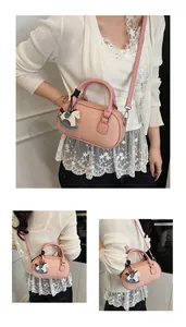 Detail view of pink bowling bag with lychee texture leather and cute horse charm