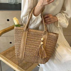 Minimalist straw woven tote bag with tassel detail for women, perfect for summer vacation
