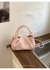 Detailansicht der hellrosa Wolken-Tasche mit Knotengriff und silbernen Metallbeschlägen