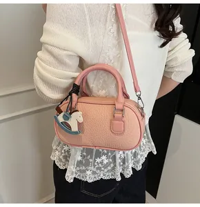 Detail of pink lychee pattern bowling bag with a colorful horse charm and strap