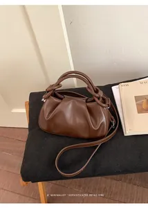 Detailansicht der dunkelbraunen Falten-Ledertasche mit Rundgriffen und abnehmbarem Gurt