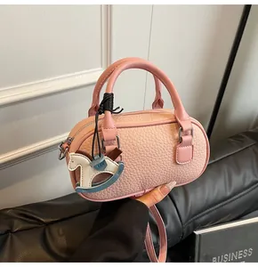 Detail of pink lychee grain bowling bag with dual handles and rocking horse charm