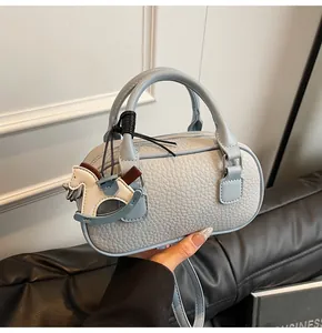 Close-up of pebble grain leather bowling bag with silver zipper and horse charm
