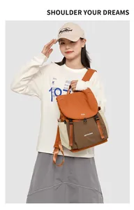 Détail d'un sac à dos en oxford bicolore avec rabat orange et poche marron porté par un mannequin