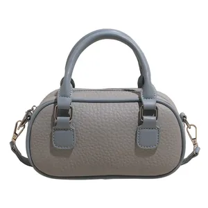Blue textured bowling bag with cylindrical handles and detachable shoulder strap